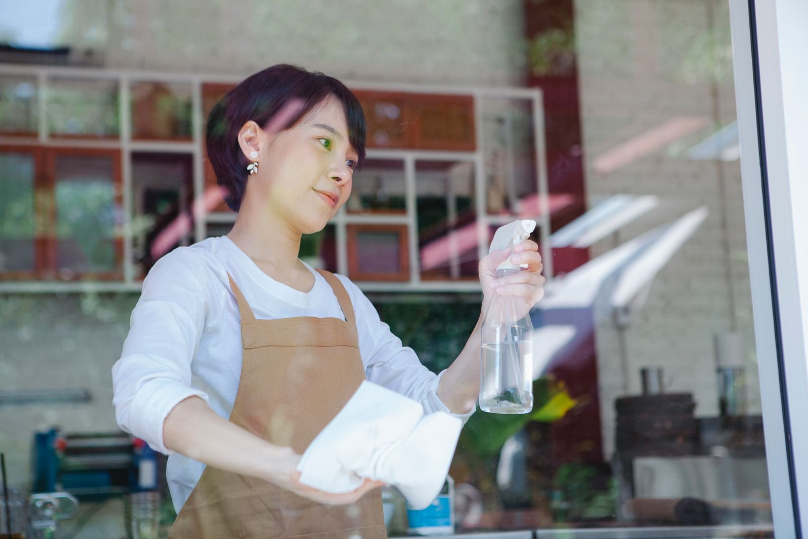 Cleaner polishing a storefront glass window